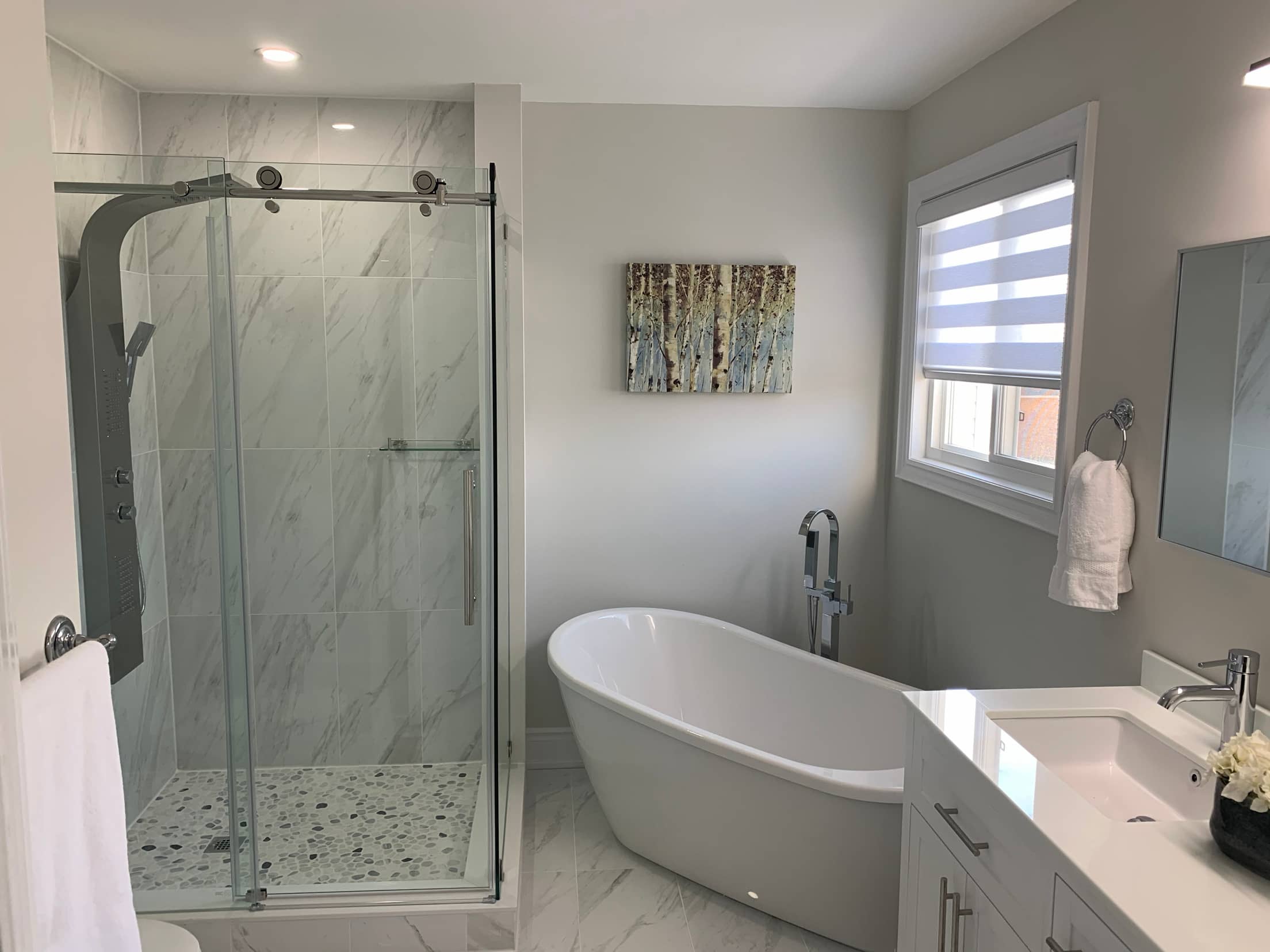 Main bathroom with a sliding glass shower, pebble tiled shower floor and a freestanding slipper tub